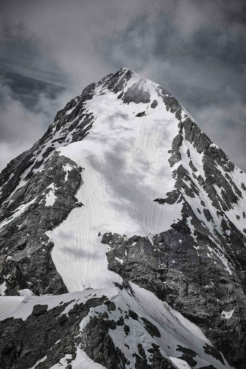 snow covered mountain under cloudy sky during daytime