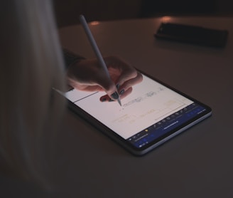 person writing on tablet