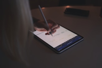 person writing on tablet
