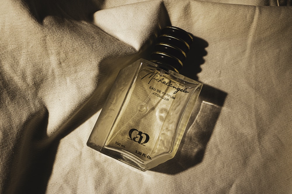 gold perfume bottle on white textile