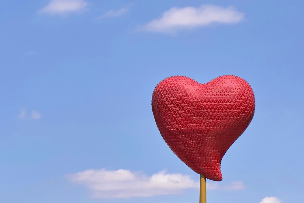 balão vermelho do coração sob o céu azul durante o dia