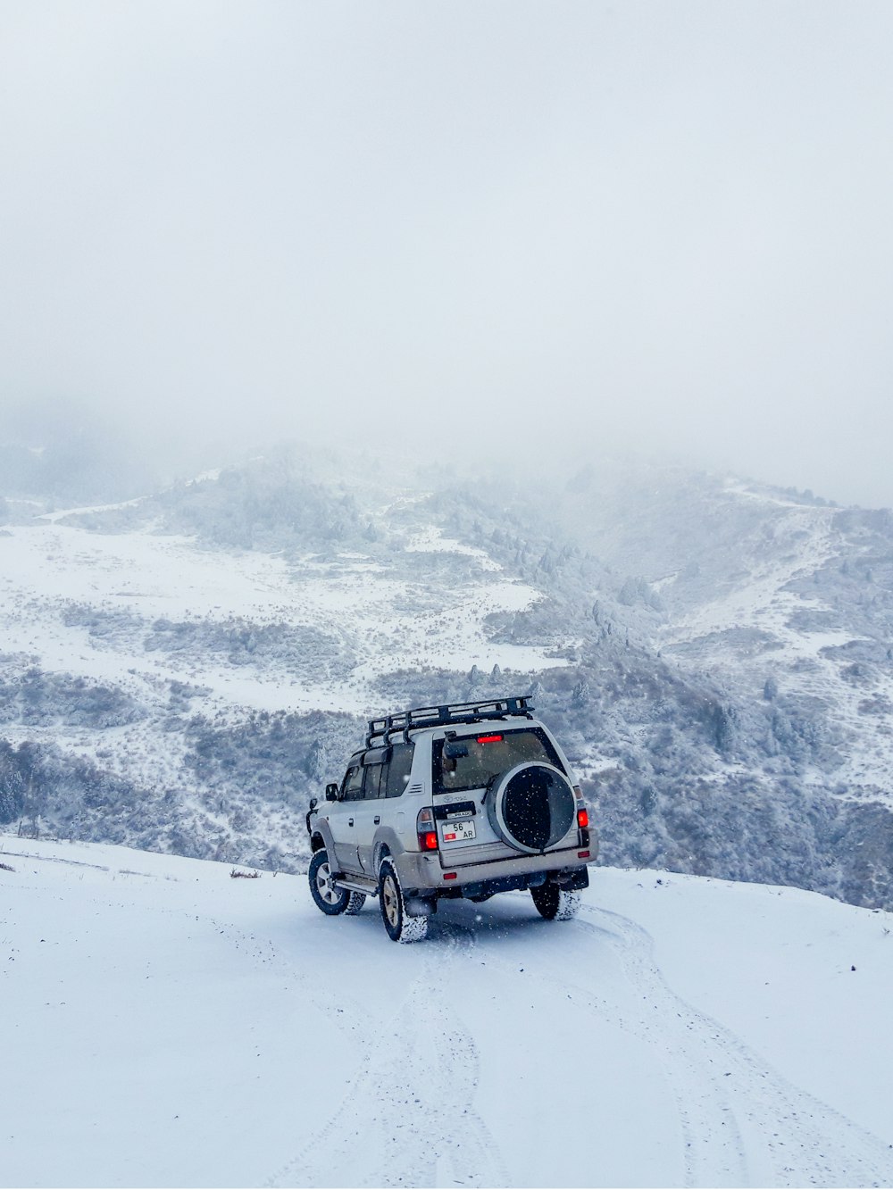 SUV blanc et noir sur une montagne enneigée pendant la journée