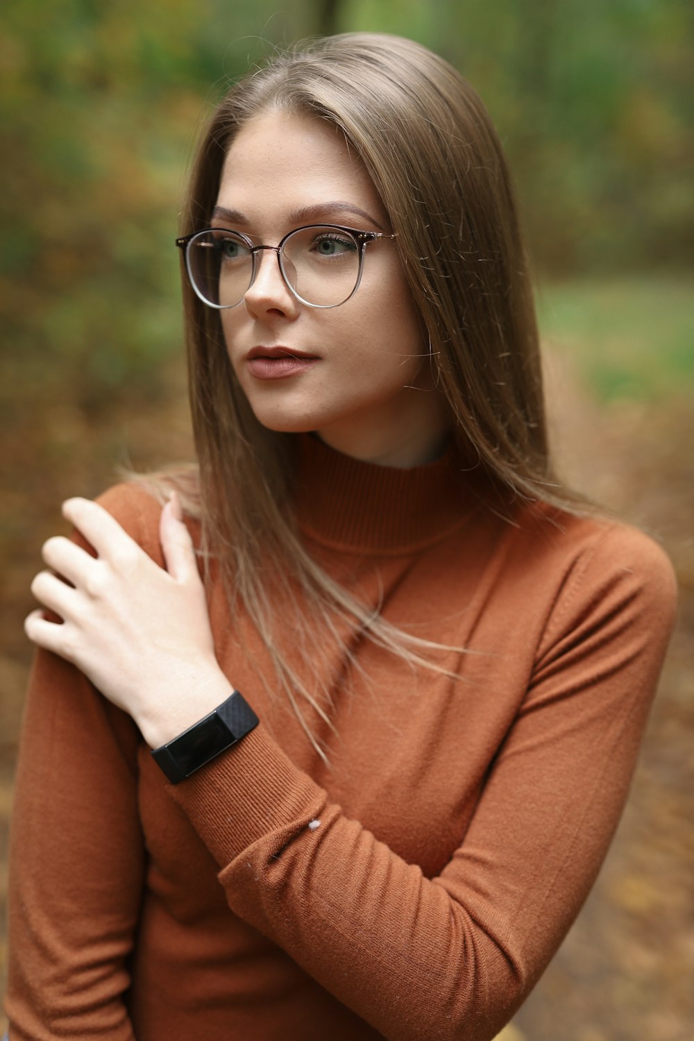 Mujer con camisa marrón de manga larga con gafas de montura negra