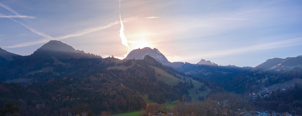 green trees on mountain under white clouds during daytime