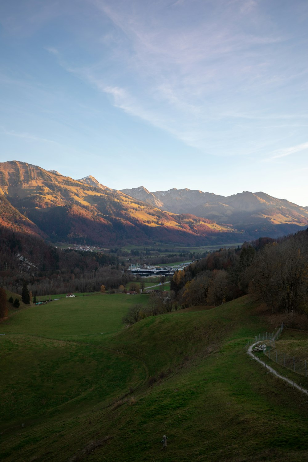 Campo di erba verde vicino alla montagna sotto cielo blu durante il giorno