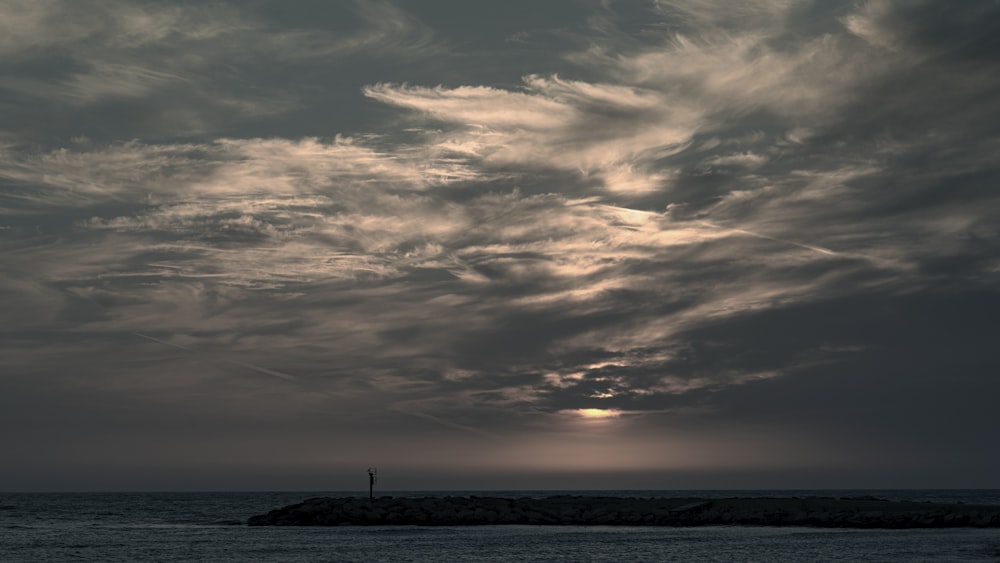 silhouette of person standing on beach during sunset