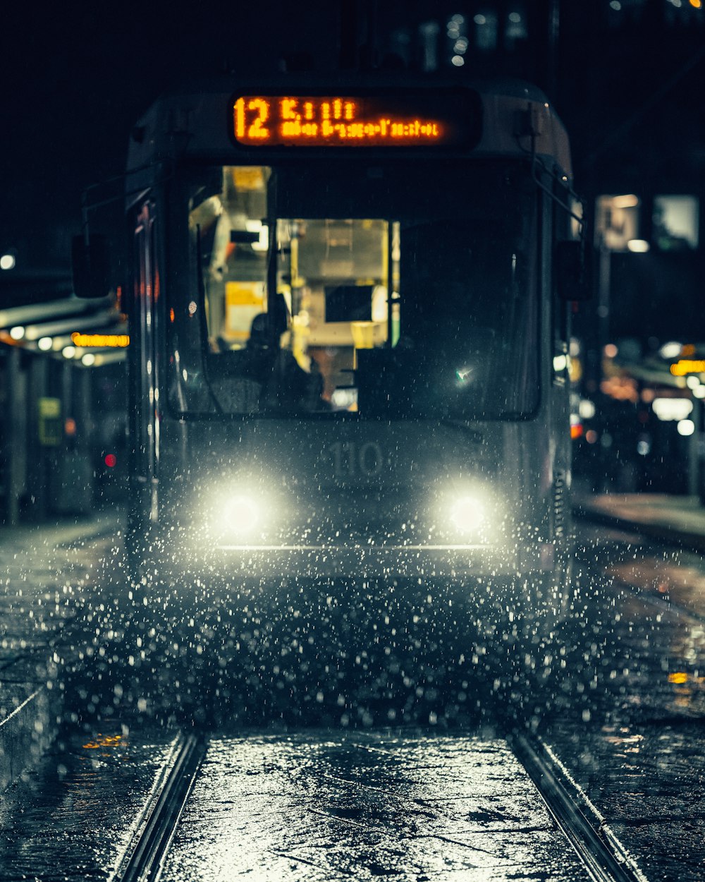 夜間の道路上の黒と黄色のバス