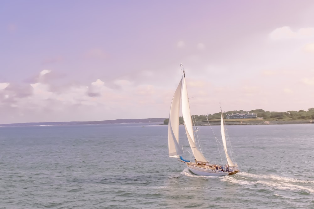 white sail boat on sea under white sky during daytime