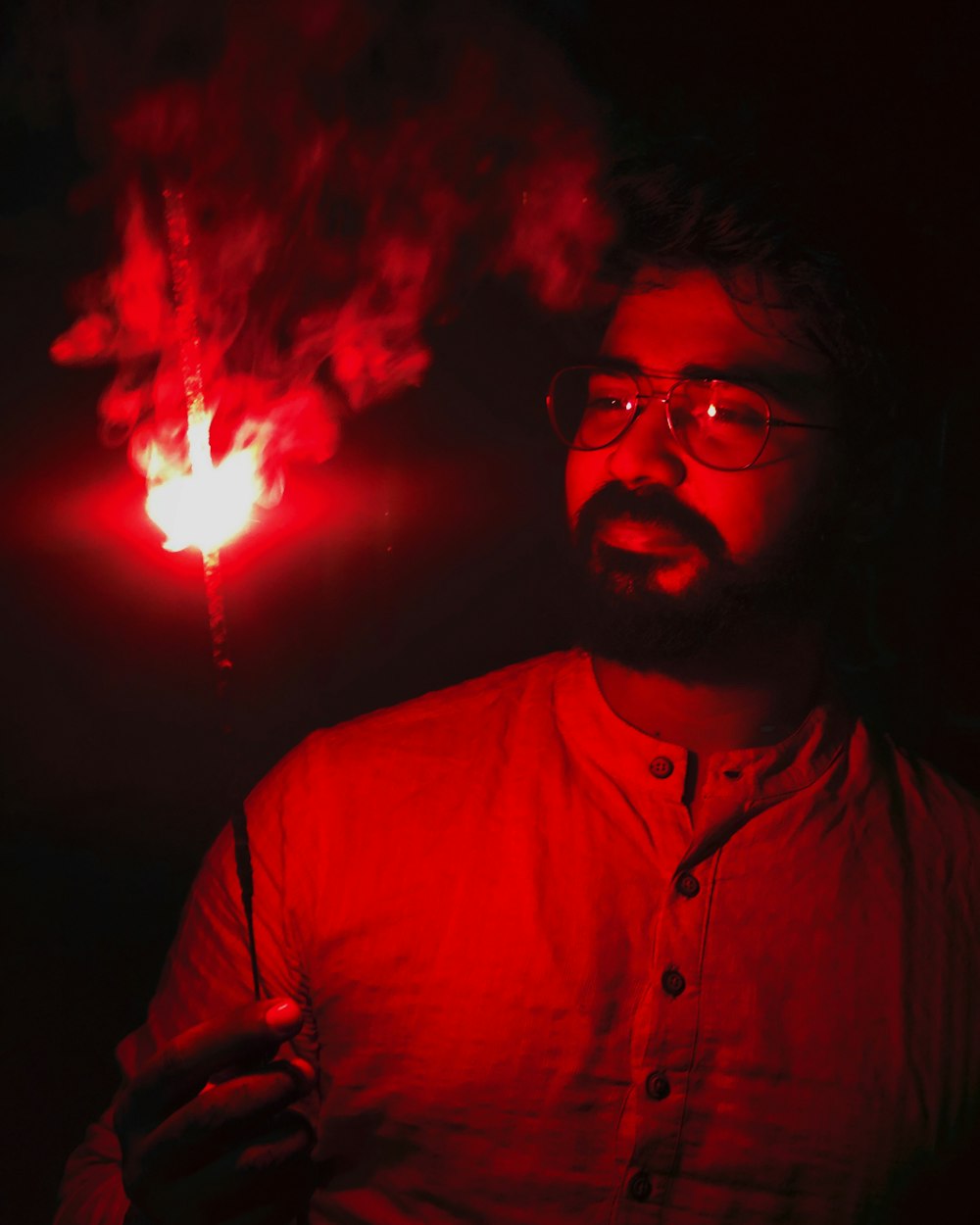 Hombre con gafas de montura negra y camisa de vestir roja