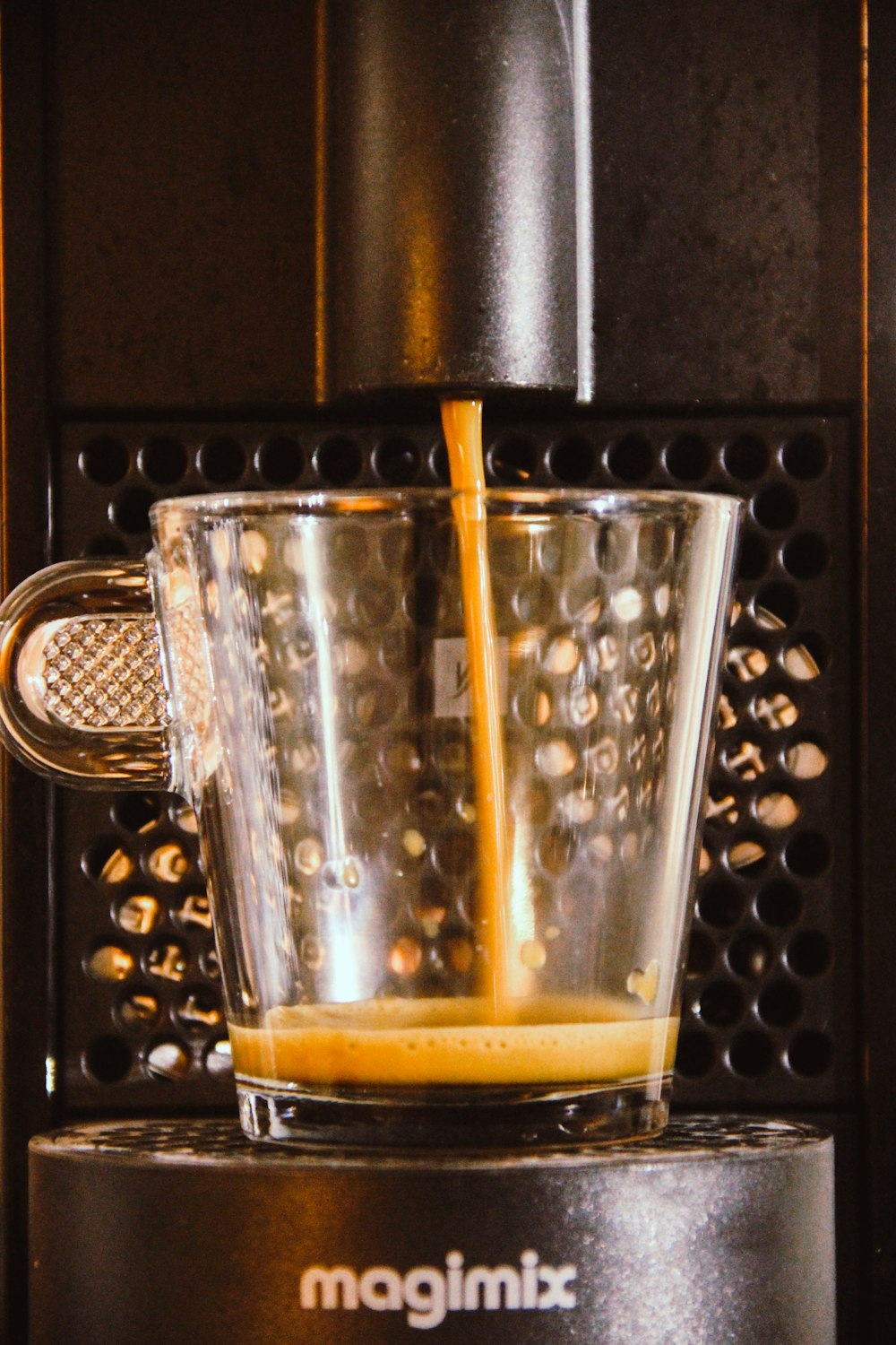 a glass of orange juice being poured into a blender