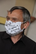 man in black suit jacket with white mask