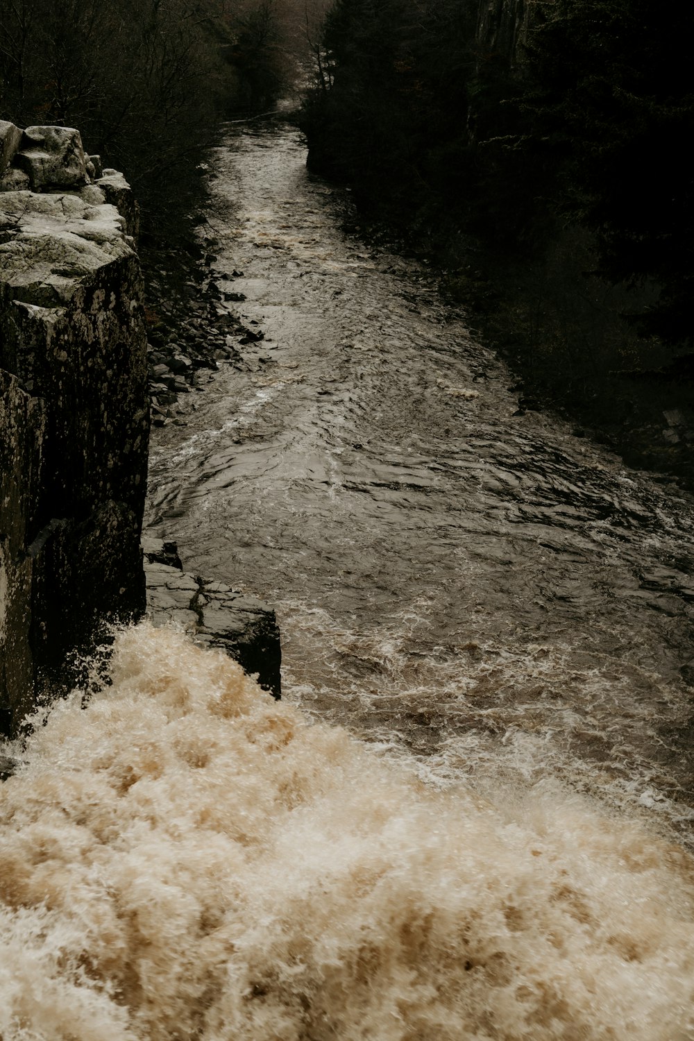 water falls on rocky shore during daytime