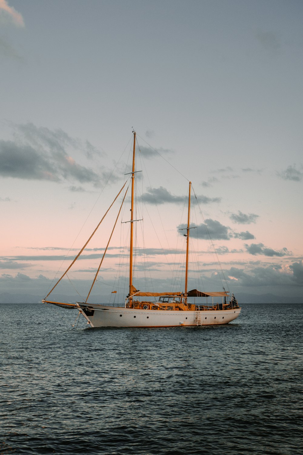 white and blue boat on sea under white clouds during daytime