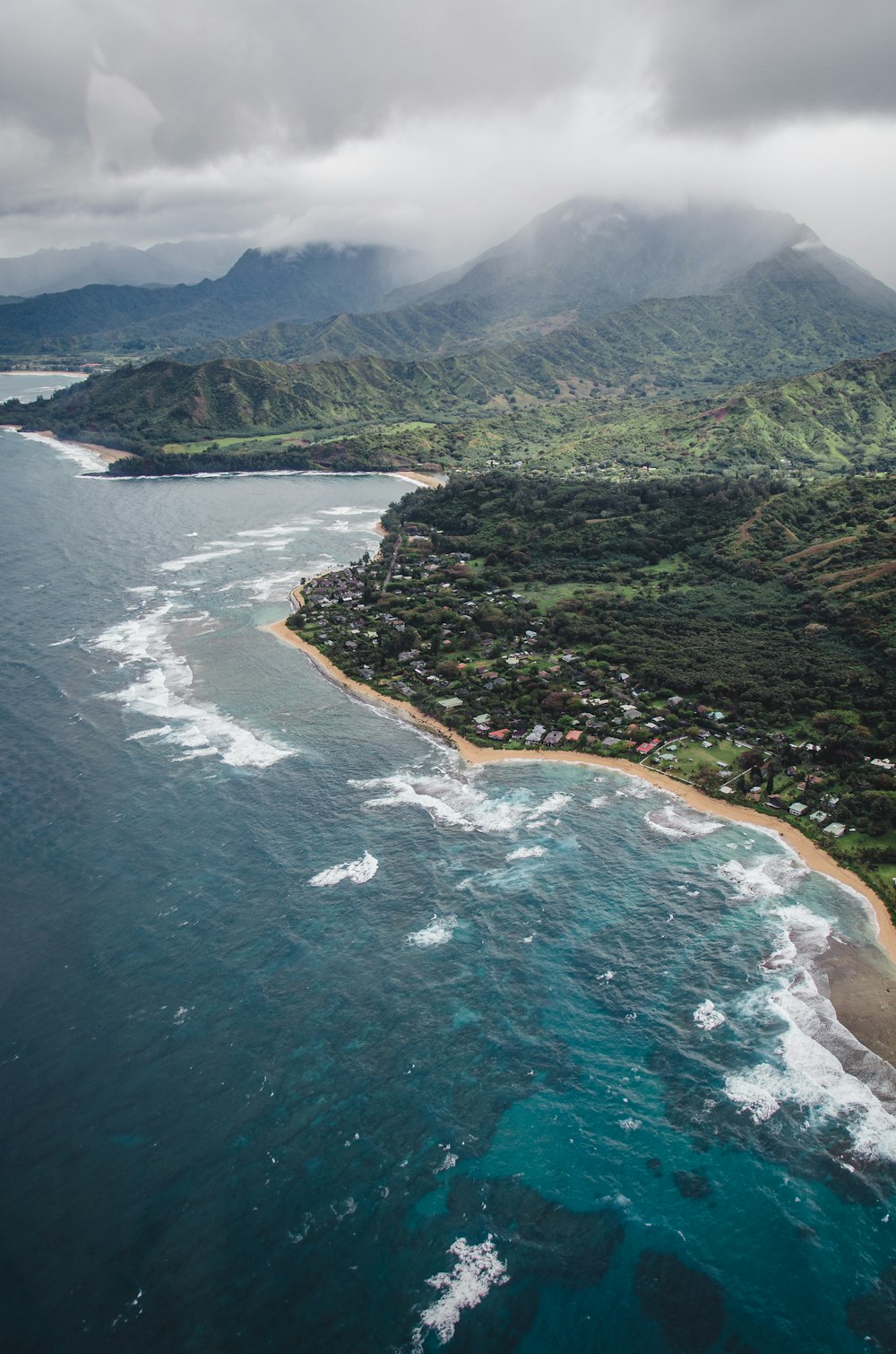 aerial view of green and brown mountain beside body of water during daytime