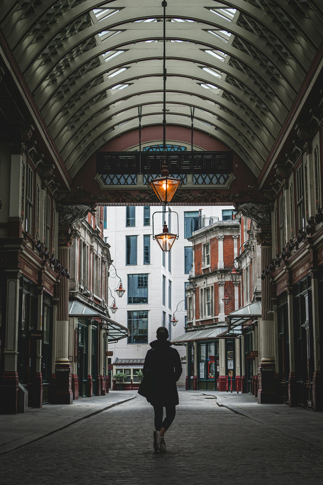 man in black jacket standing in front of building during daytime