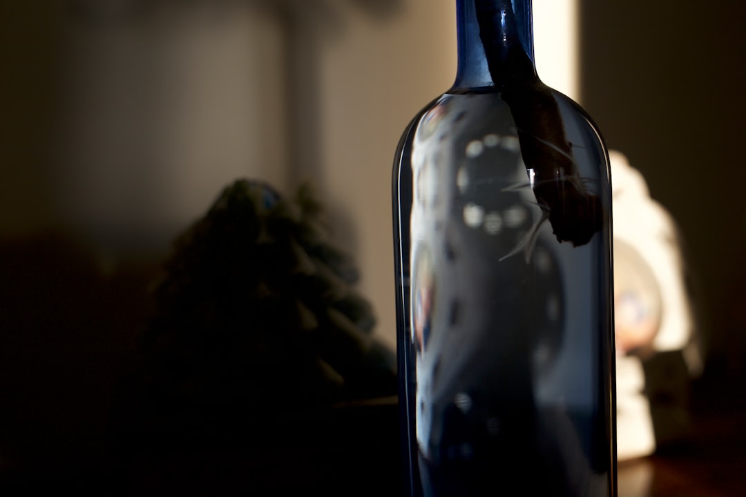black glass bottle on brown wooden table