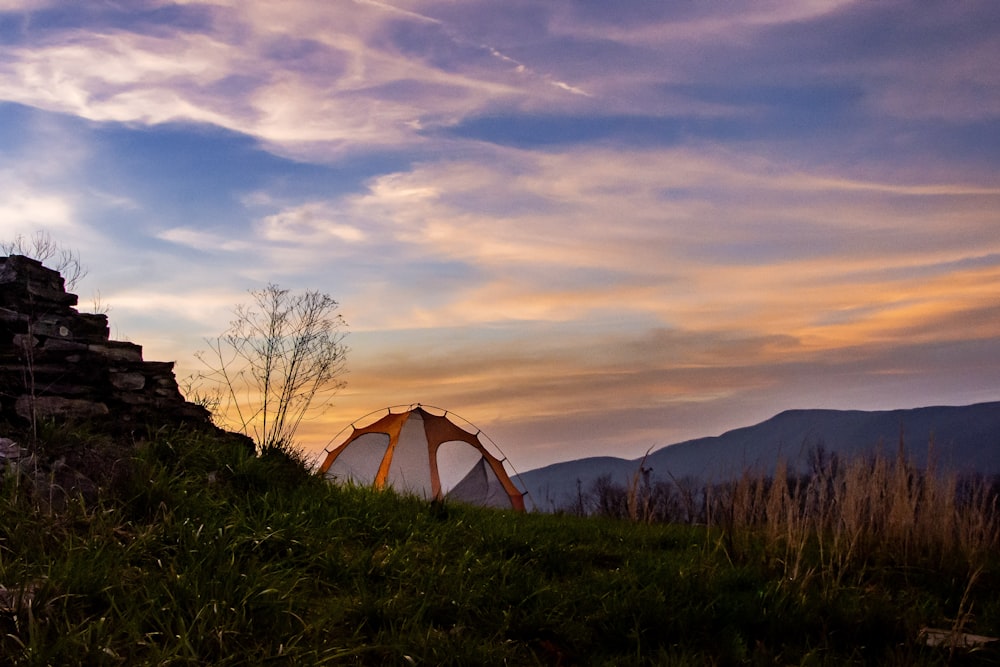 white tent on green grass field during sunset