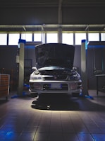 Corporate vehicle being inspected for maintenance with hood open.