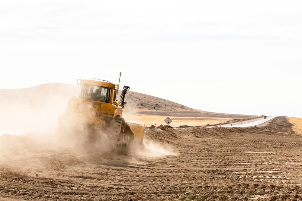 yellow and black heavy equipment on desert during daytime