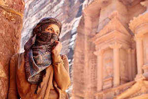 woman in brown hijab standing near brown concrete building during daytime