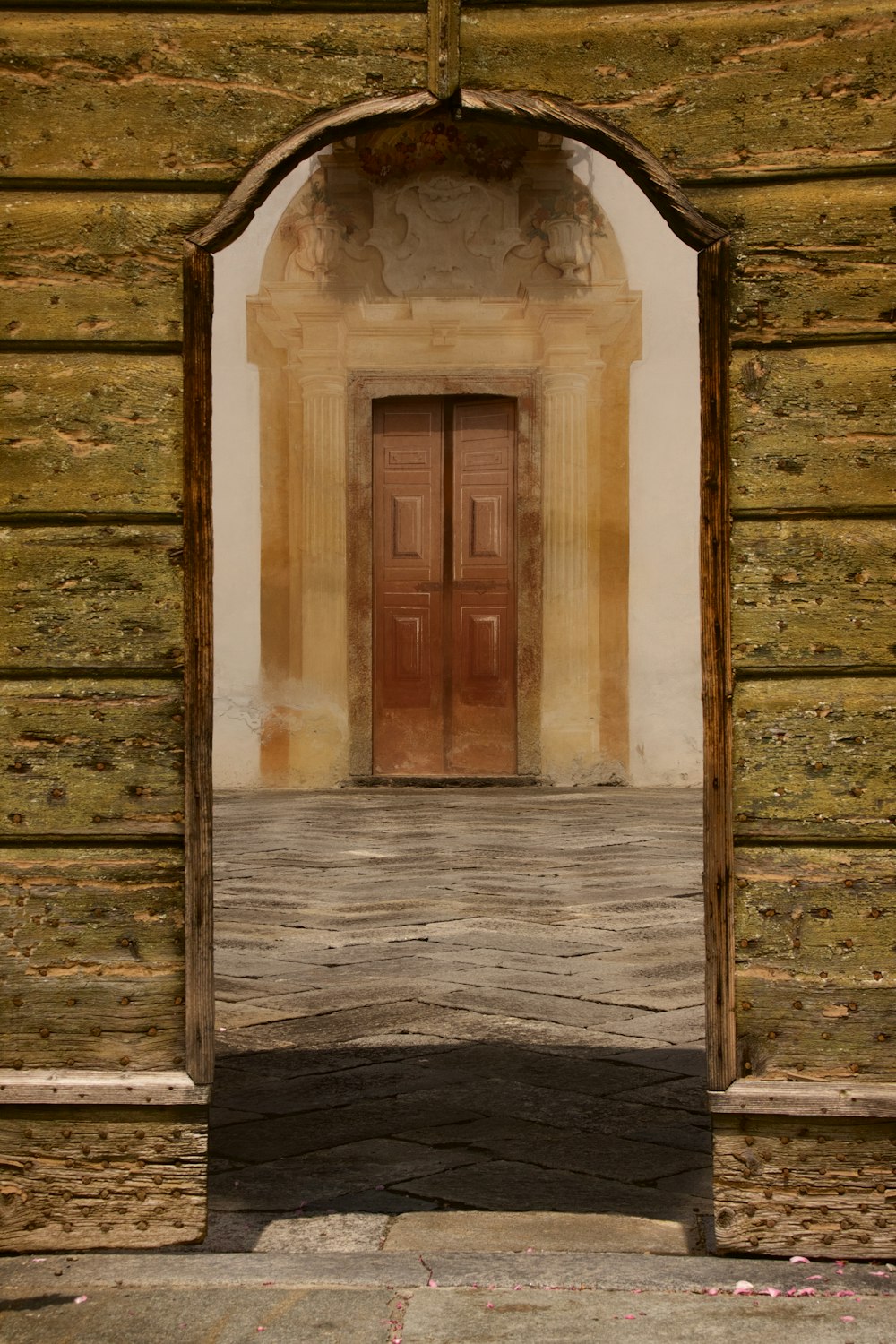 brown wooden door in white concrete building