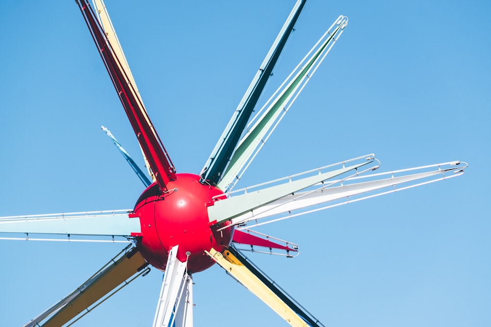 red and white wind mill under blue sky during daytime