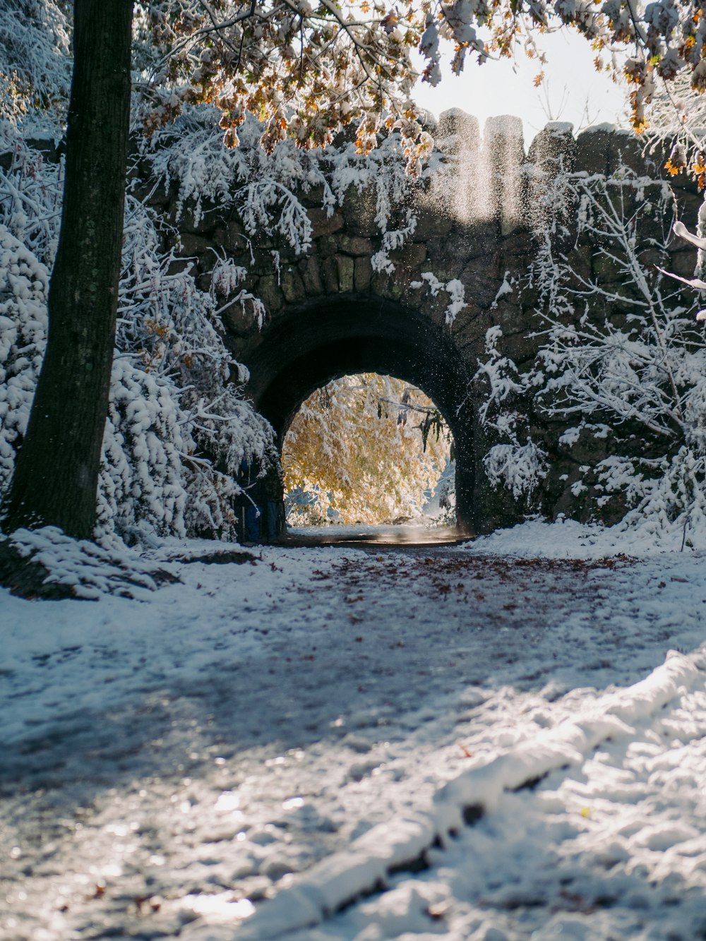 gray concrete arch with snow during daytime