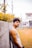 man in white tank top standing near gray concrete wall during daytime