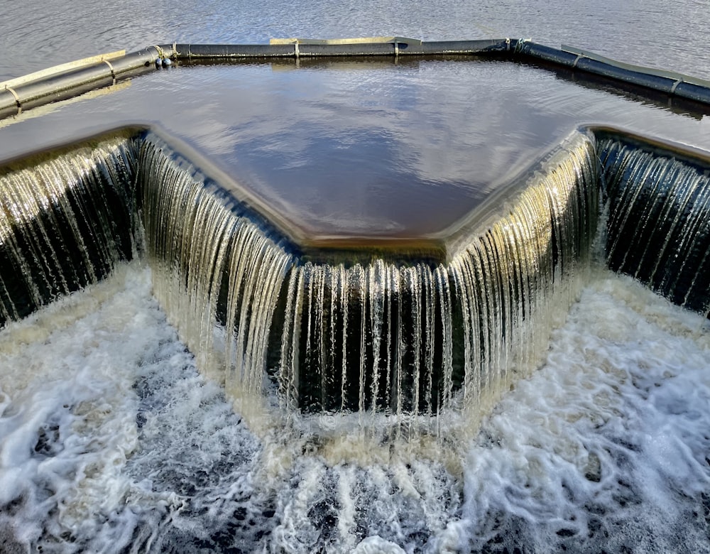 agua cayendo de una piscina de hormigón marrón