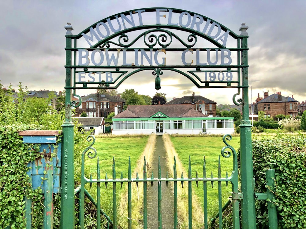 green metal fence with welcome to the beach signage