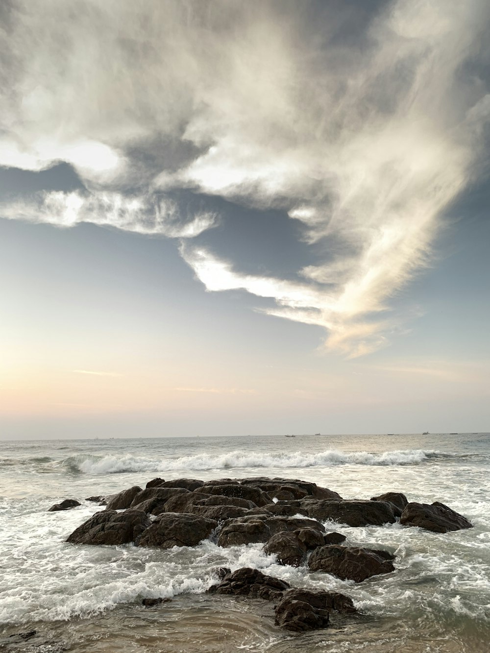 brown rock formation on sea under blue sky during daytime