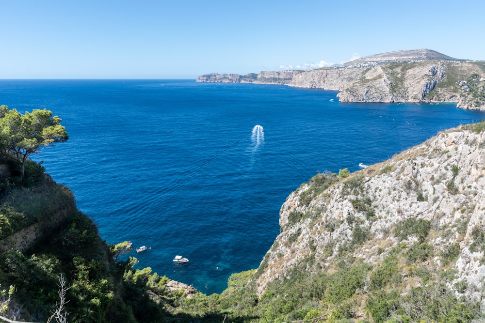 Barco blanco en el mar cerca de la montaña durante el día