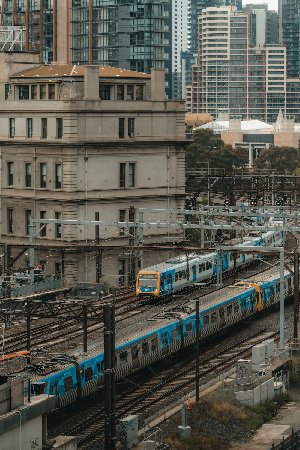 white and blue train in the city during daytime