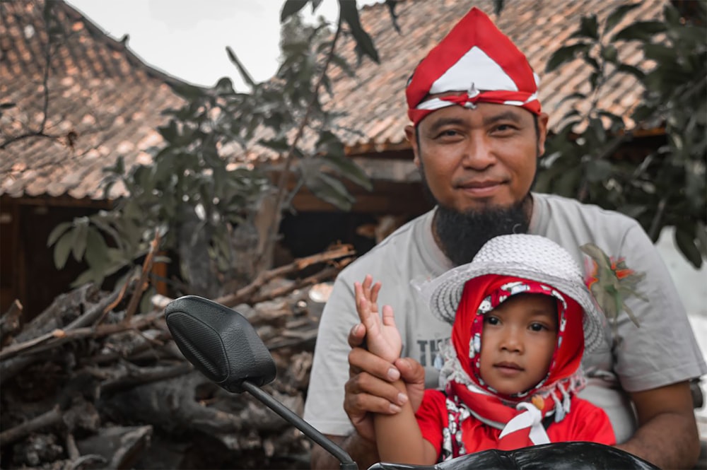 boy in red and white santa hat holding black motorcycle handle bar