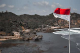 white and red flag on rocky shore during daytime