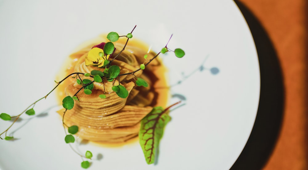 pasta with green leaf on white ceramic plate