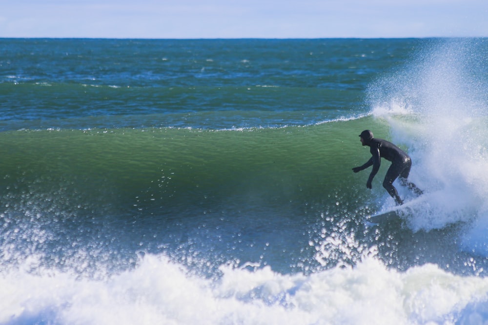 man surfing on sea waves during daytime