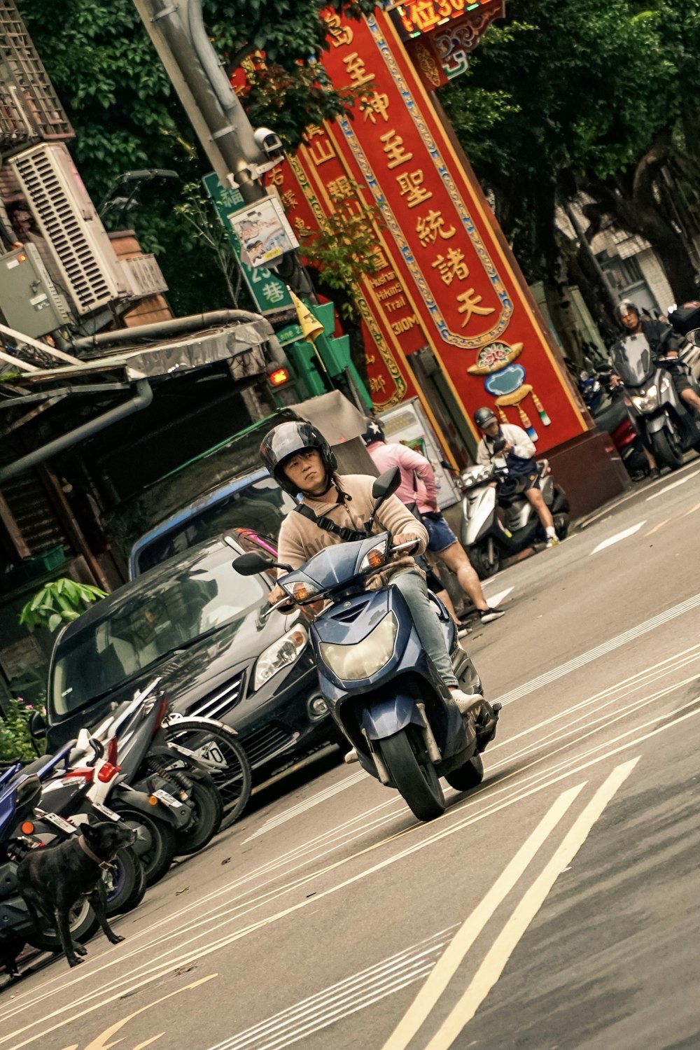 man in blue jacket riding on black motor scooter on road during daytime