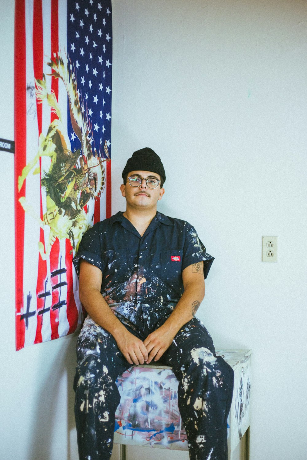 man in black and white button up shirt sitting on bed