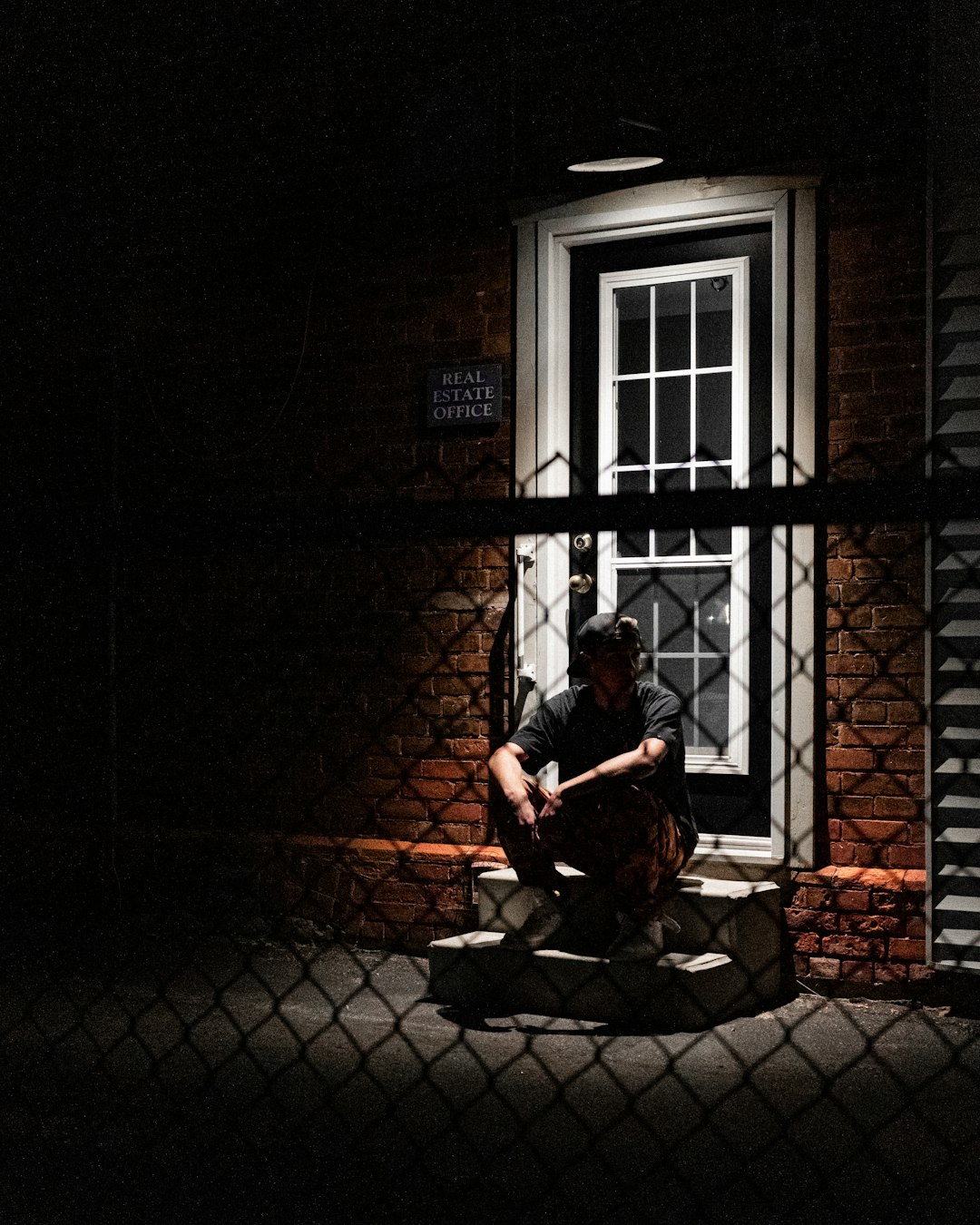 man in red shirt sitting on brown wooden bench