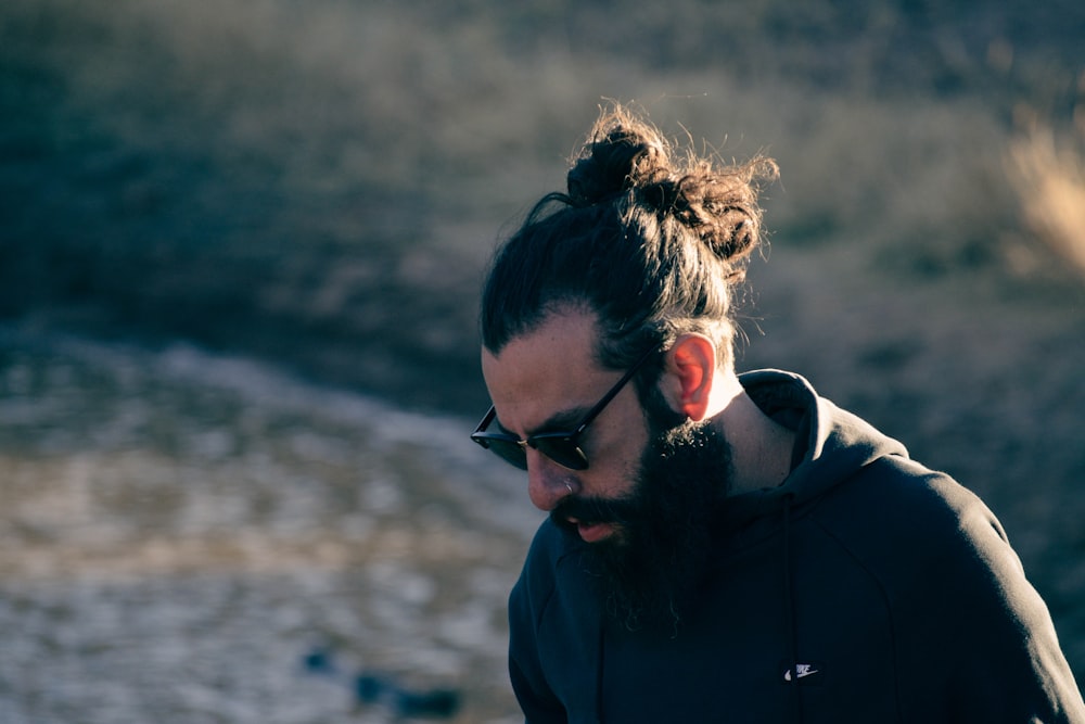 Homme en veste noire portant des lunettes à monture noire