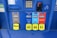 A gas station pump panel featuring four fuel options: Diesel, Regular, Extra, and Supreme+, each with distinct colors and labels. The panel includes pricing displays and a card payment slot. Each fuel option has a yellow button indicating the octane rating. The panel is predominantly blue with some black and red elements.