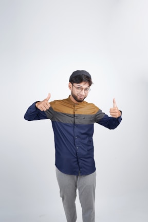 Smiling graduate giving a thumbs up with colorful background