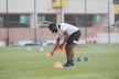 man in white shirt and black shorts playing soccer during daytime