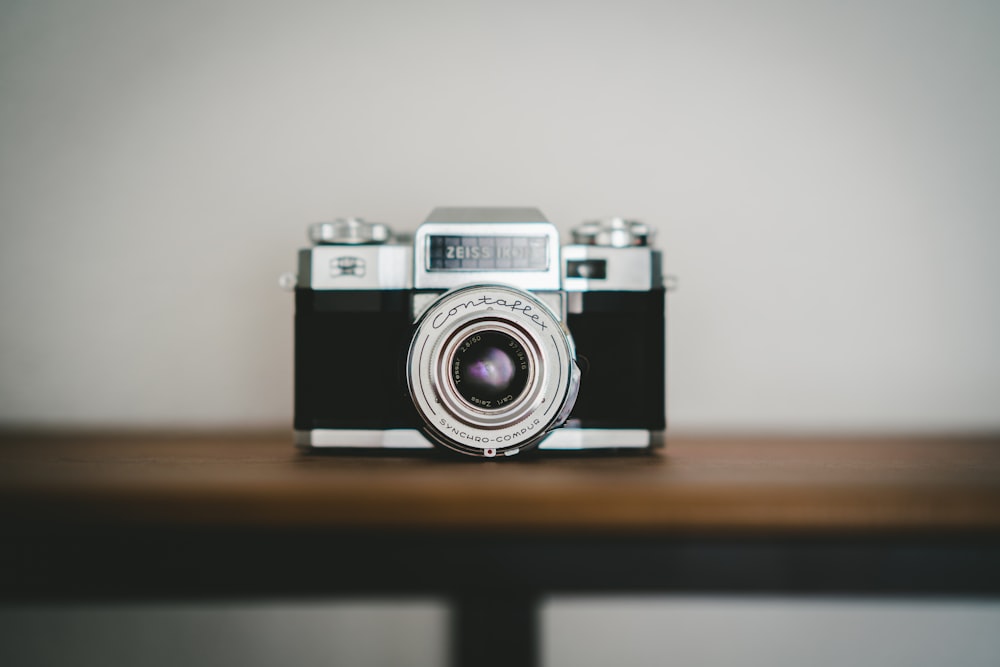 black and silver camera on brown wooden table