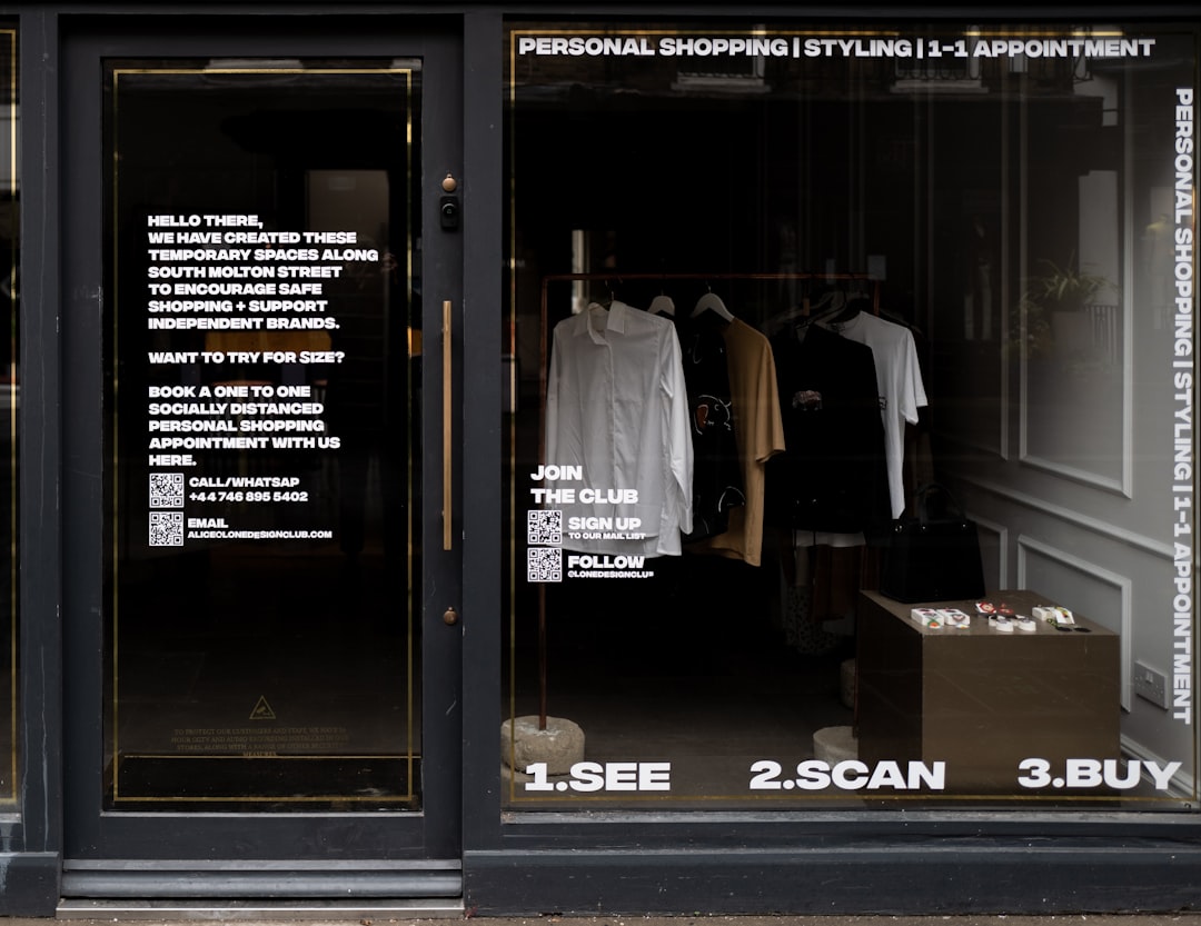 white dress shirt hanging on brown wooden cabinet, Shoppable store front as shops are closed again because of Covid 19.