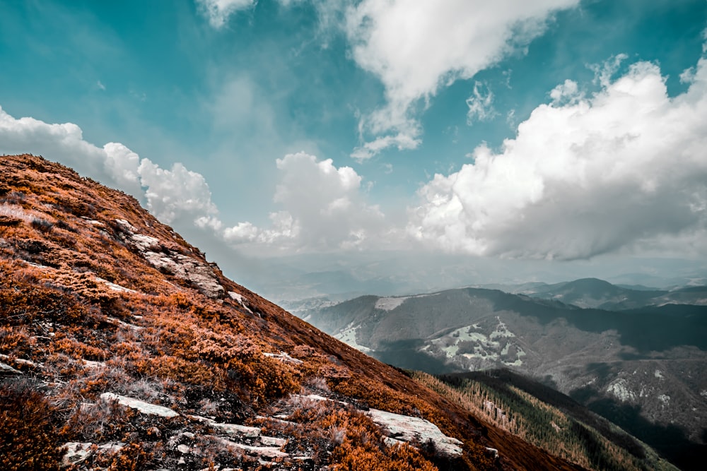 brown and white mountains under blue sky and white clouds during daytime