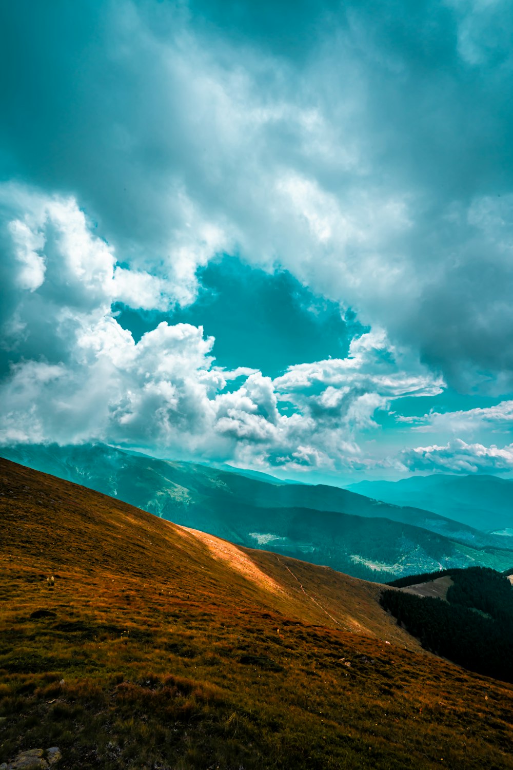 brown and green mountain under white clouds and blue sky during daytime