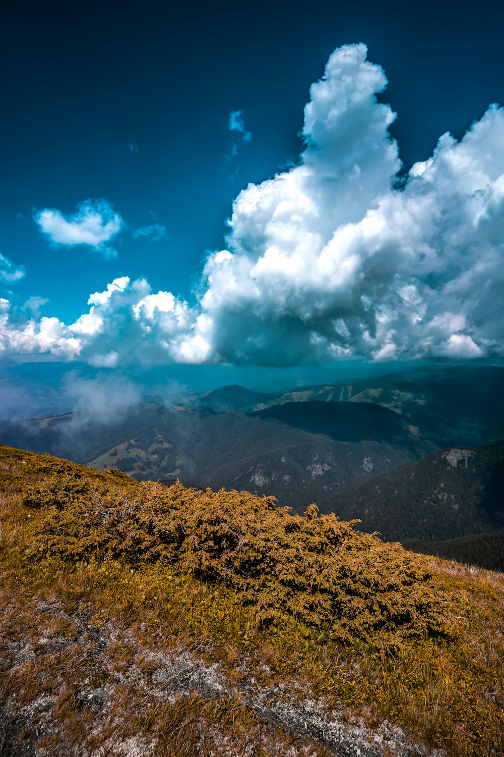 brown mountain under white clouds and blue sky during daytime