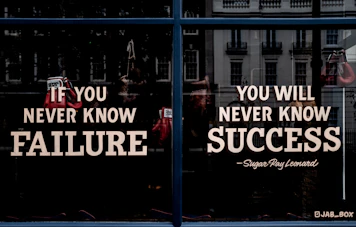 Boxing gloves hanging in a window with text about failure and success